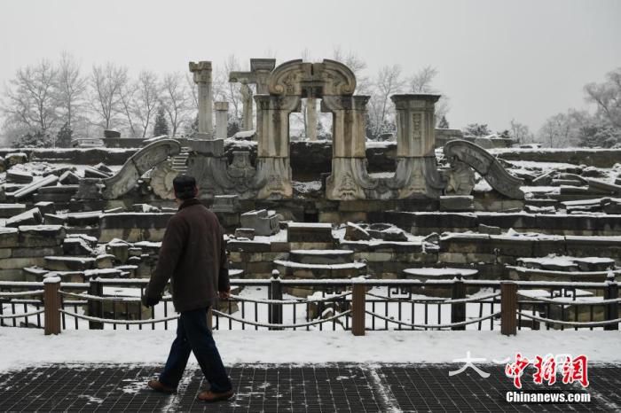 12月16日,北京迎來大雪天氣,一名遊客在圓明園內欣賞雪景。<a target= 點擊進入下一頁